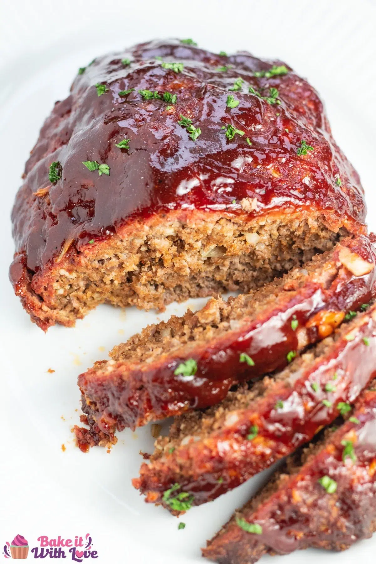 Tall overhead of the sliced smoked meatloaf on white platter.