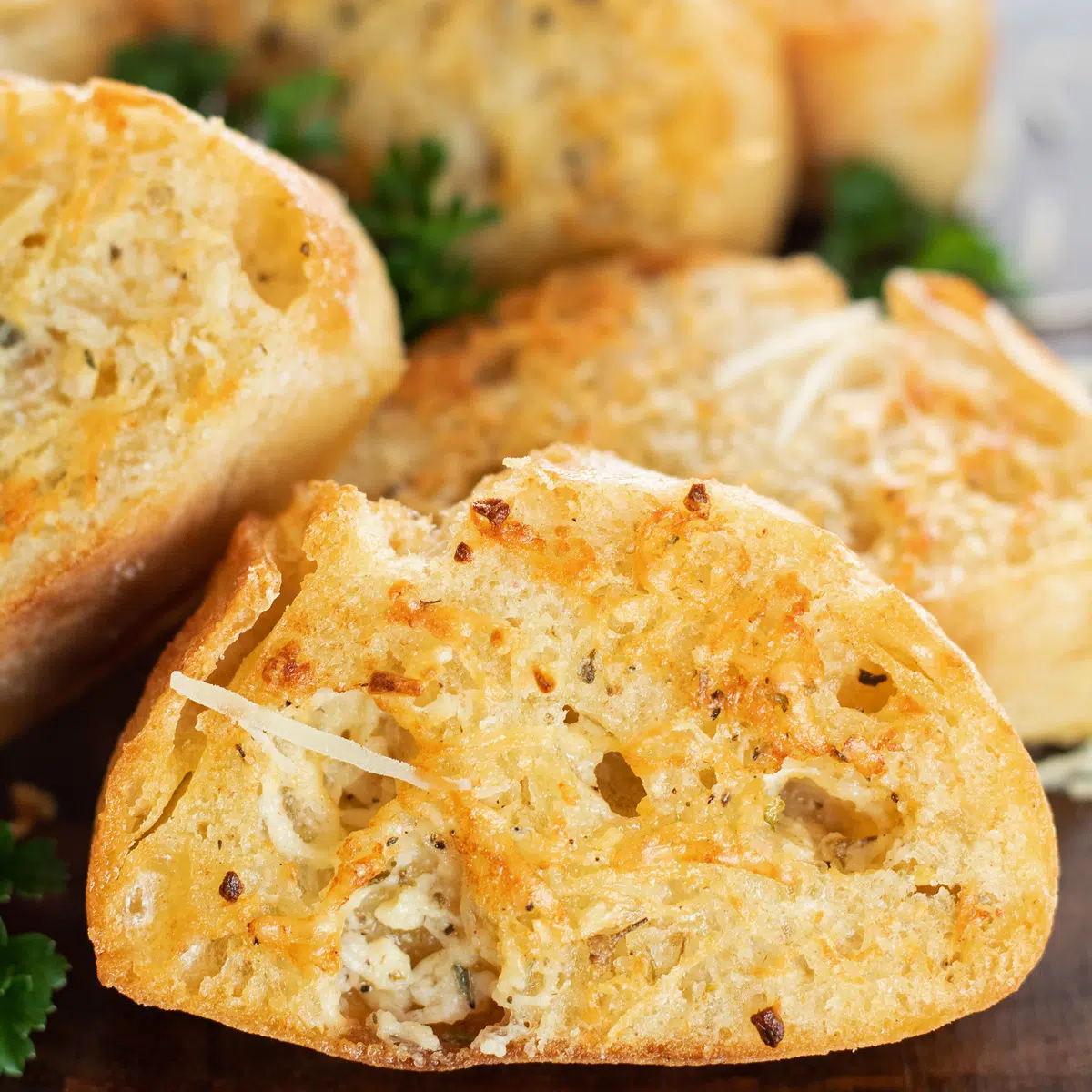 Irisan roti bawang putih yang dipanggang dengan sempurna di atas talenan kayu.