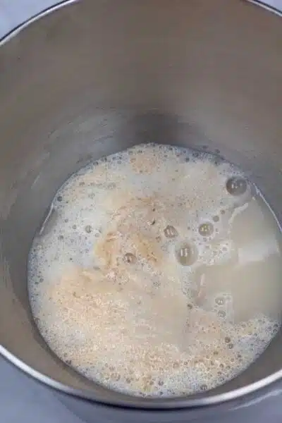 Process photo 2 of transferring the activated, frothy yeast mixture into bowl.
