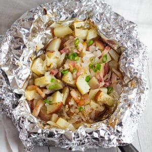 Cut up red potatoes in foil with bacon, onion, and garlic.