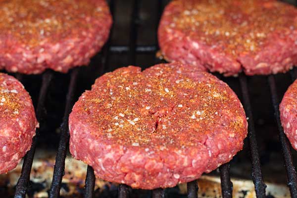 Process photo 4 of the burger patties transferred onto the smoker grill.