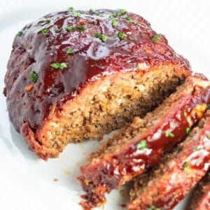 Smoked meatloaf topped with BBQ glaze and sliced to serve.