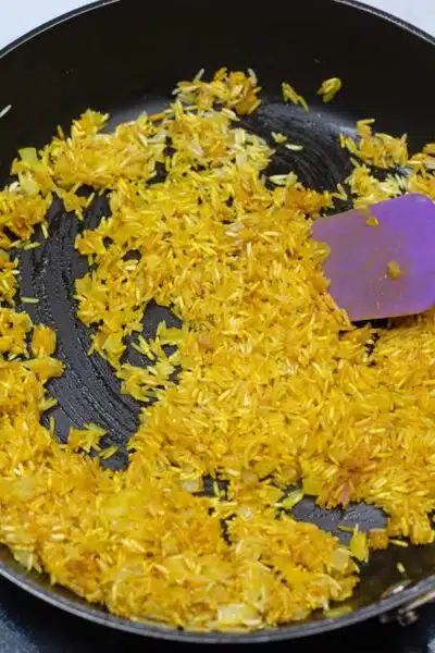 Process photo 5 of the rice and turmeric combined with sauteed onion and garlic.