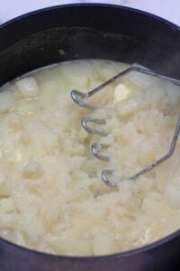 Processo da foto 6 amassando as batatas cozidas.