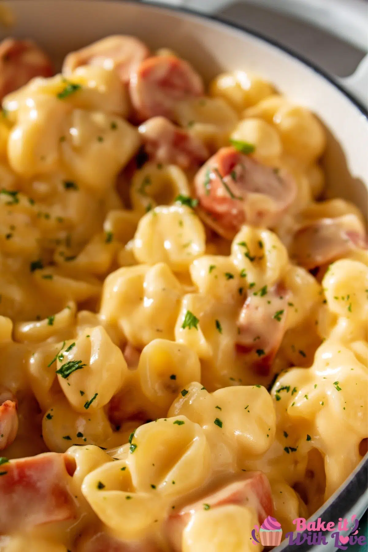 Tall closeup of the mac and cheese with hot dogs in pot.