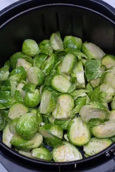 Process photo 2 prepared brussel sprouts in air fryer basket.