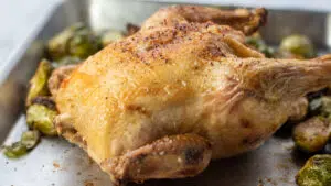 Wide image of the air fryer Cornish hen on baking sheet.