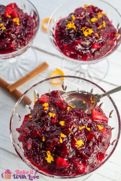 Tall image of the apple cider cranberry sauce in crystal dishes.