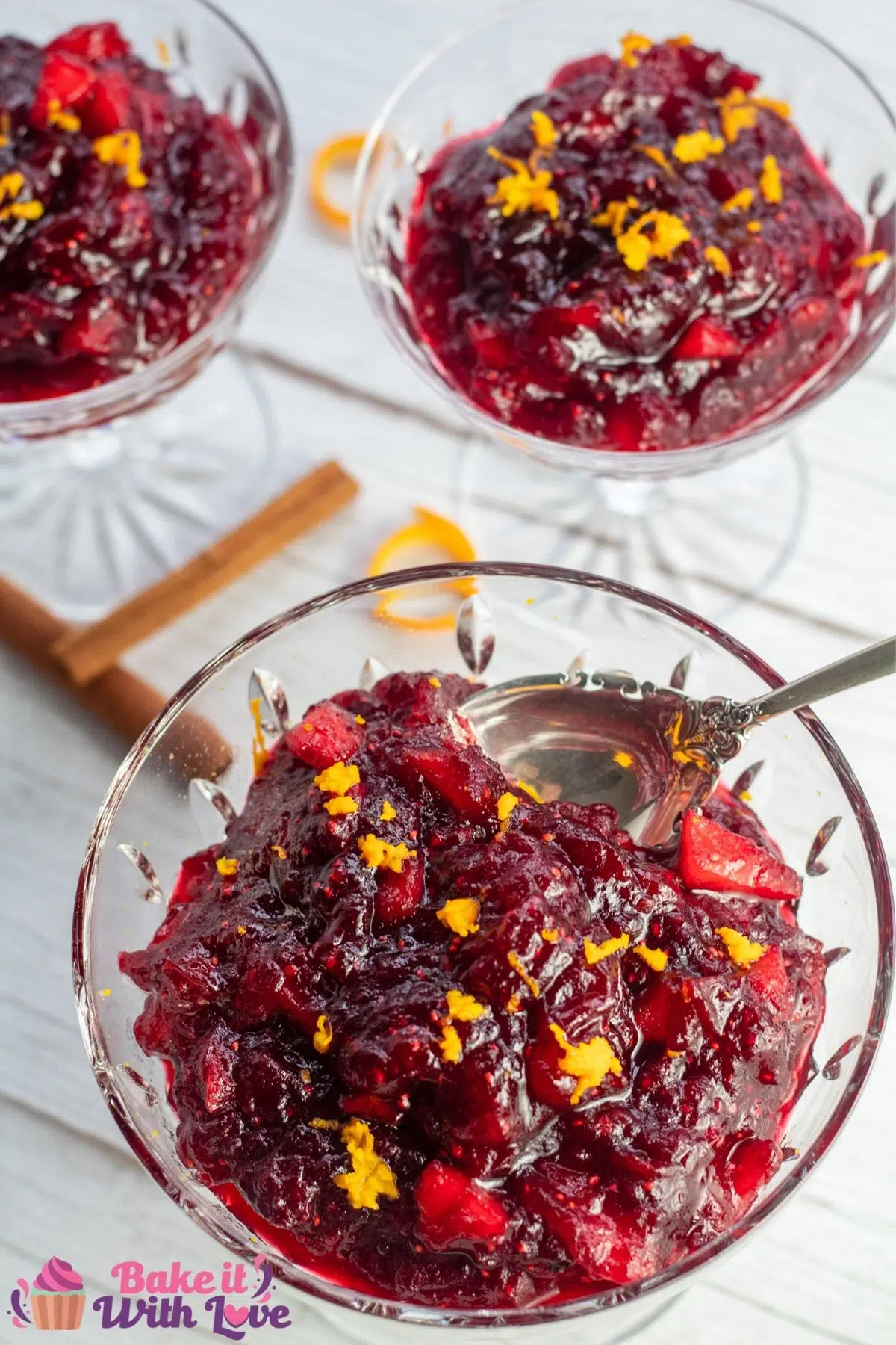 Tall image of the apple cider cranberry sauce in crystal dishes.