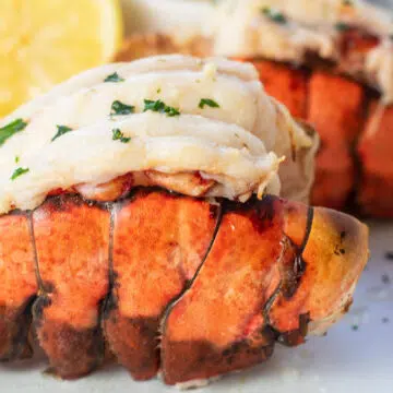 Wide image from the side of the broiled lobster tail.