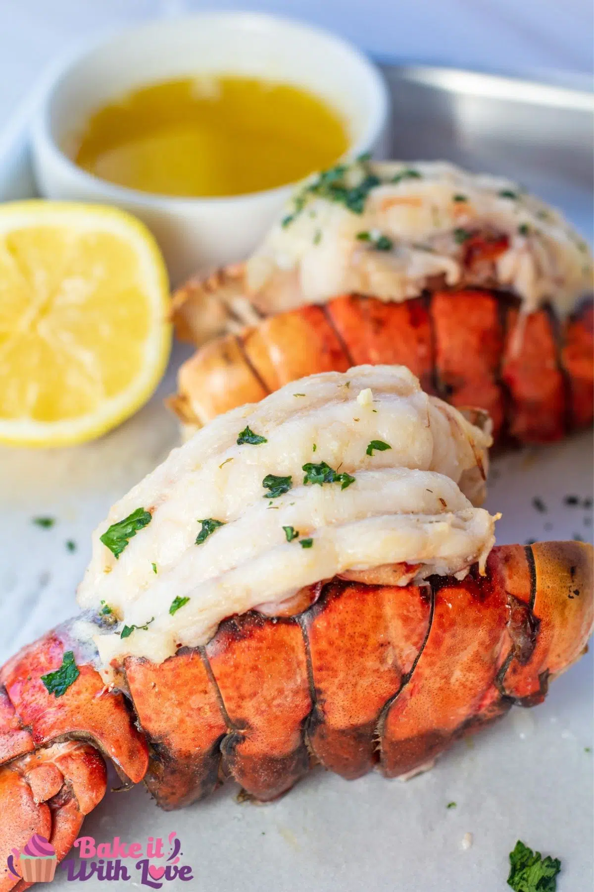 Tall image of the broiled lobster tails on sheet pan.