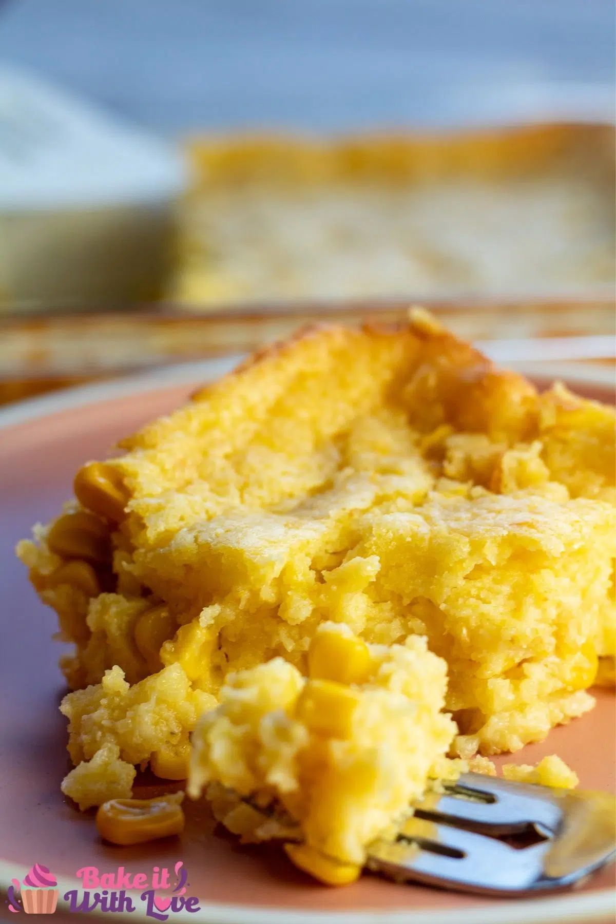Tall image of the Jiffy corn casserole with a bite on fork.