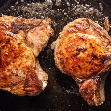 Image of seared pork chops in a pan.