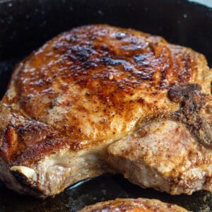 Pan seared pork chop close up in a pan.