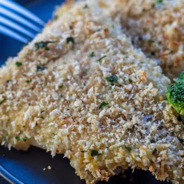 Panko baked cod served up nice and crispy out of the oven on black plate.