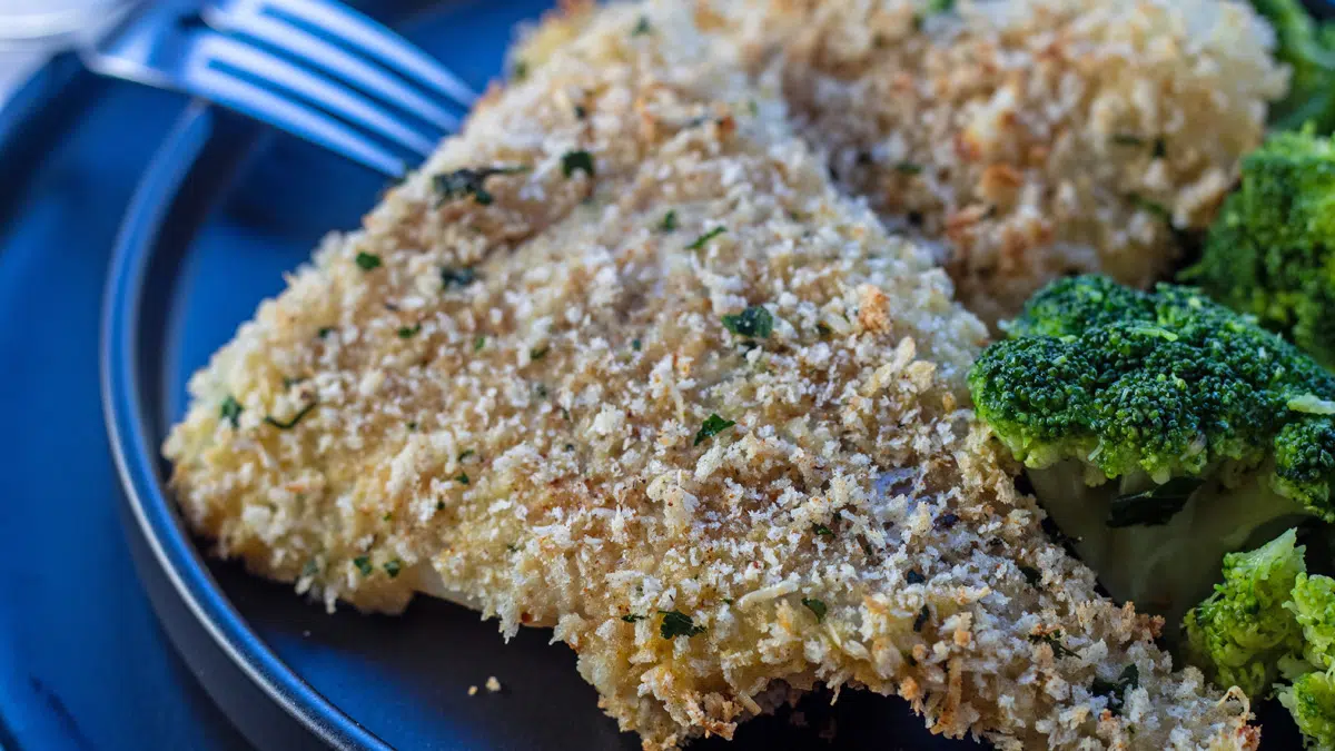 Panko baked cod served up nice and crispy out of the oven on black plate.