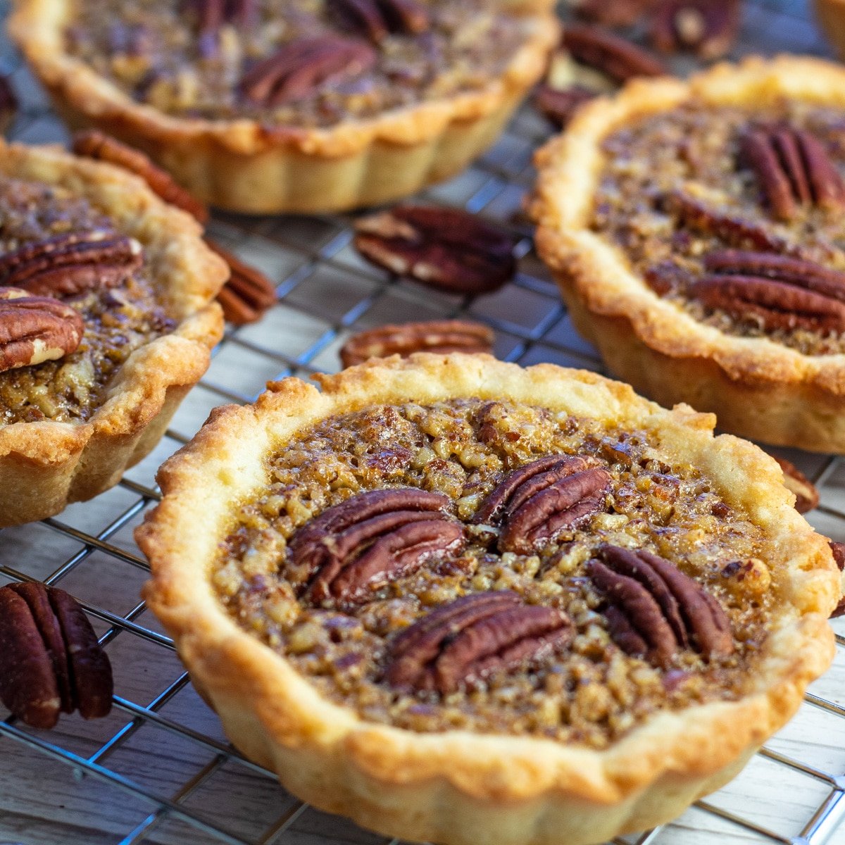 Pecan tartlets closeup on topping and pecans.