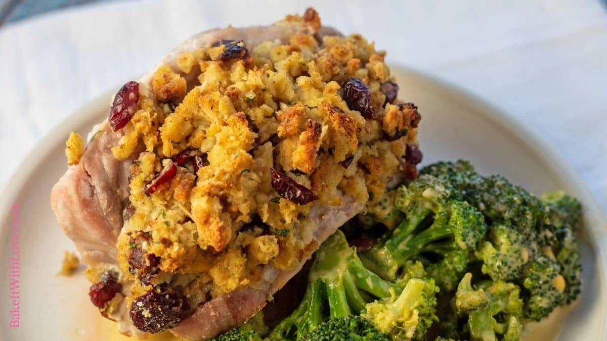 Wide image of pork chops stuffed with stuffing on a plate.