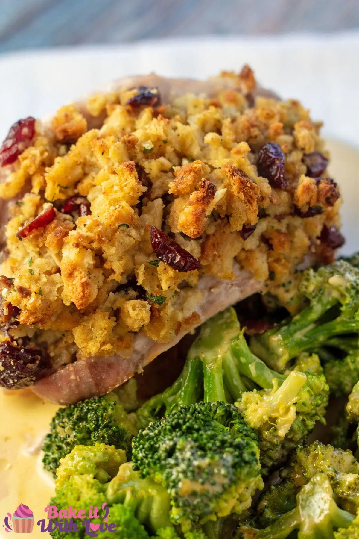 Tall image of the stuffing stuffed pork chops served with broccoli.
