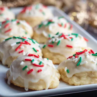 Italian ricotta Christmas cookies decorated with icing and festive red and green sprinkles.