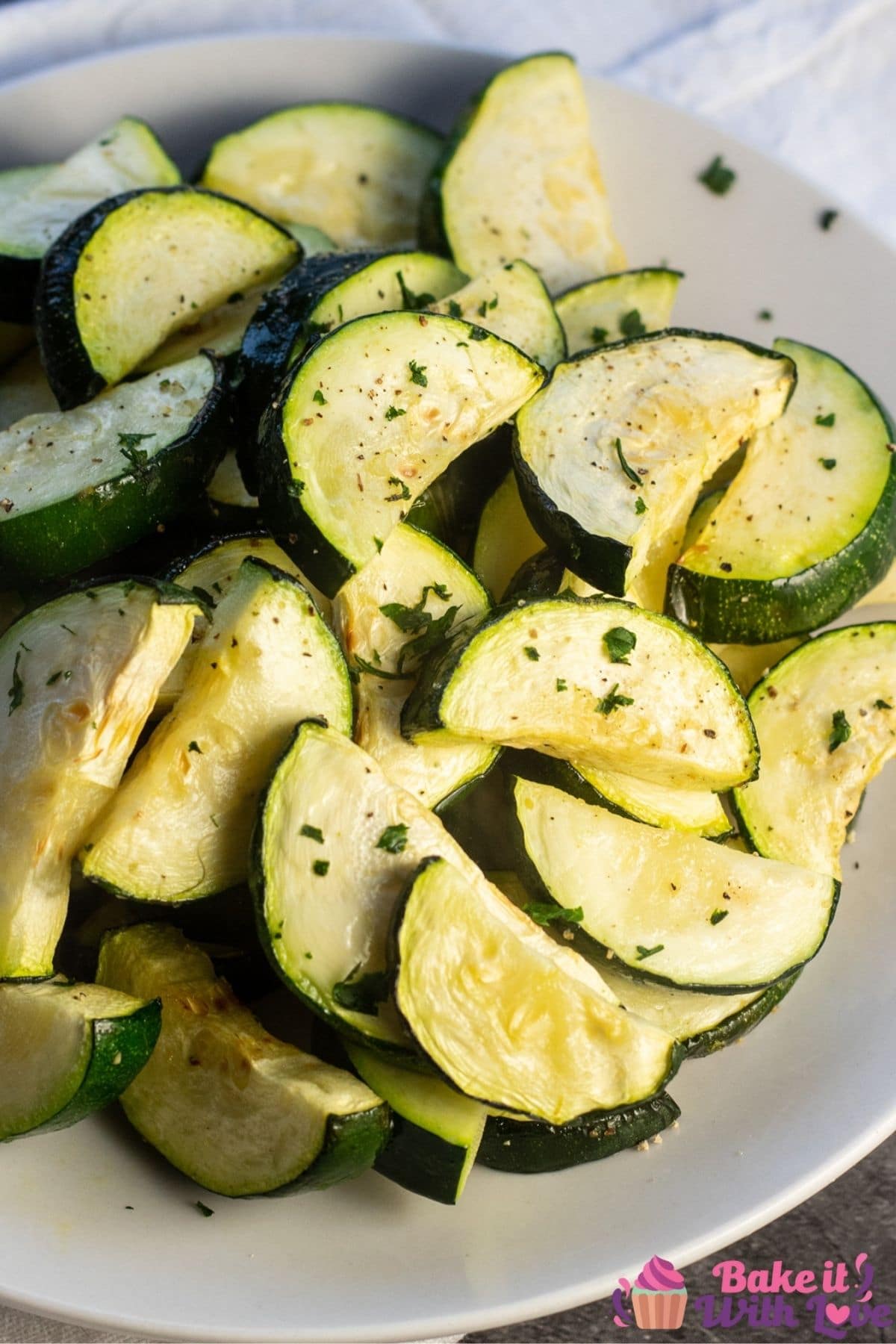 Air fryer zucchini plated on white plate with parsley garnish.