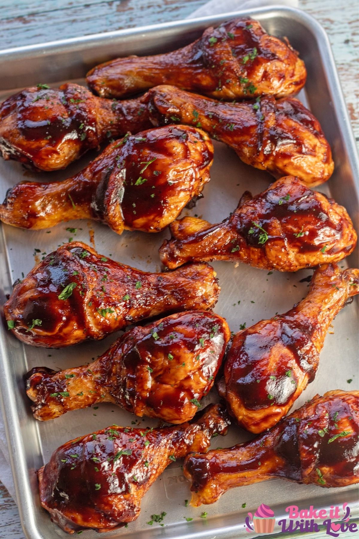 Overhead of the baked bbq chicken drumsticks on metal tray.