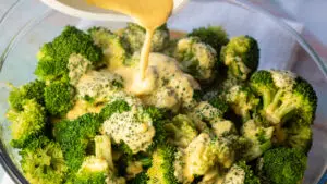 Wide image of the cheese sauce for broccoli being poured.