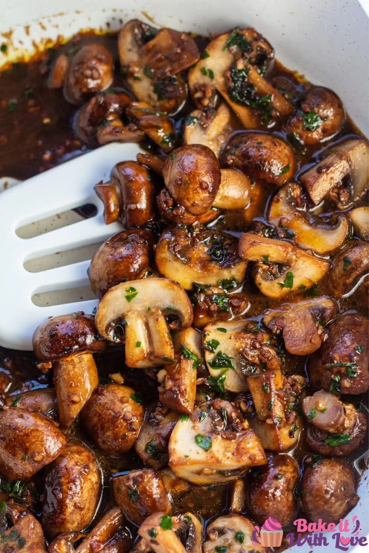 Tall overhead of the sauteed garlic butter mushrooms in light colored skillet.