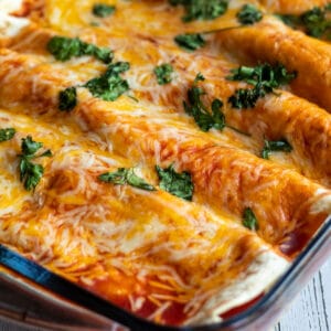 Reste von Truthahn-Enchiladas mit geschmolzenem Käse und Koriander.