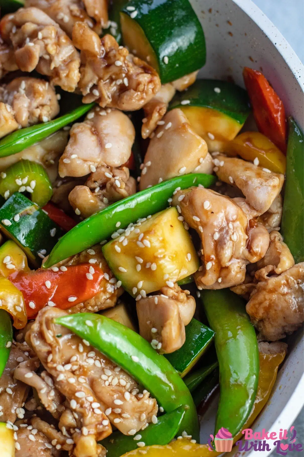 Tall overhead of the teriyaki chicken stir fry in light colored skillet.