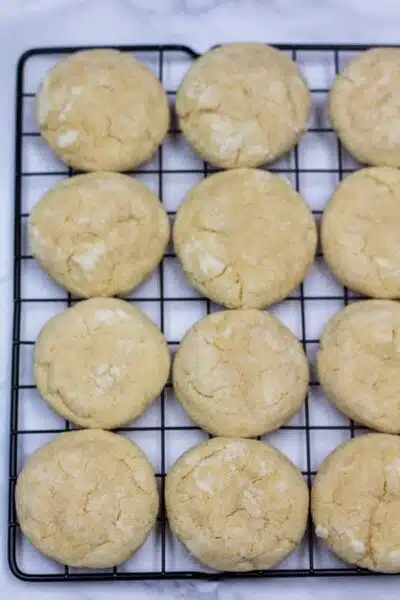 Process photo 8 baked vanilla crinkle cookies on cooling rack.