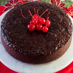Square image looking down on the Jamaican black cake, with cherries on top of cake.