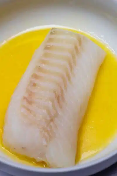 Process image 1 showing cod fillet in melted butter.
