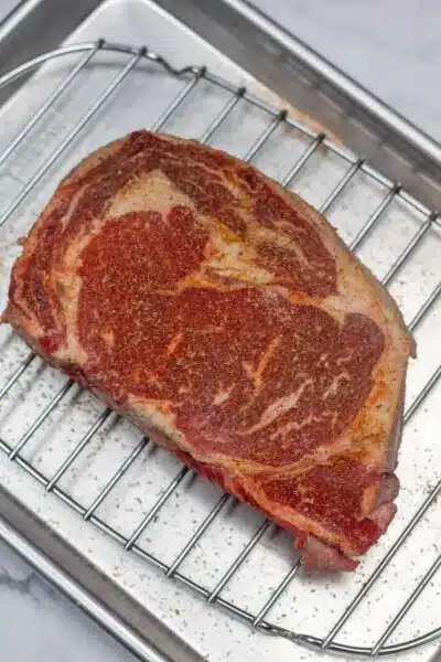 Process photo 1 showing seasoned ribe eye steak.