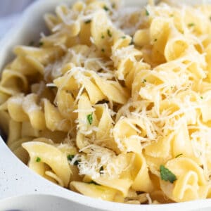 Primo piano sulle tagliatelle imburrate con prezzemolo e parmigiano.