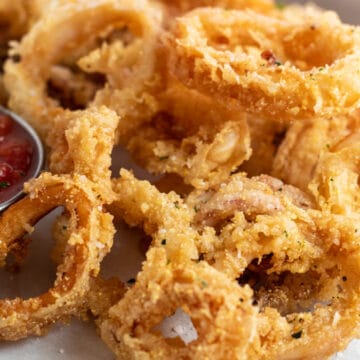 Wide image of the deep fried calamari with marinara for dipping.