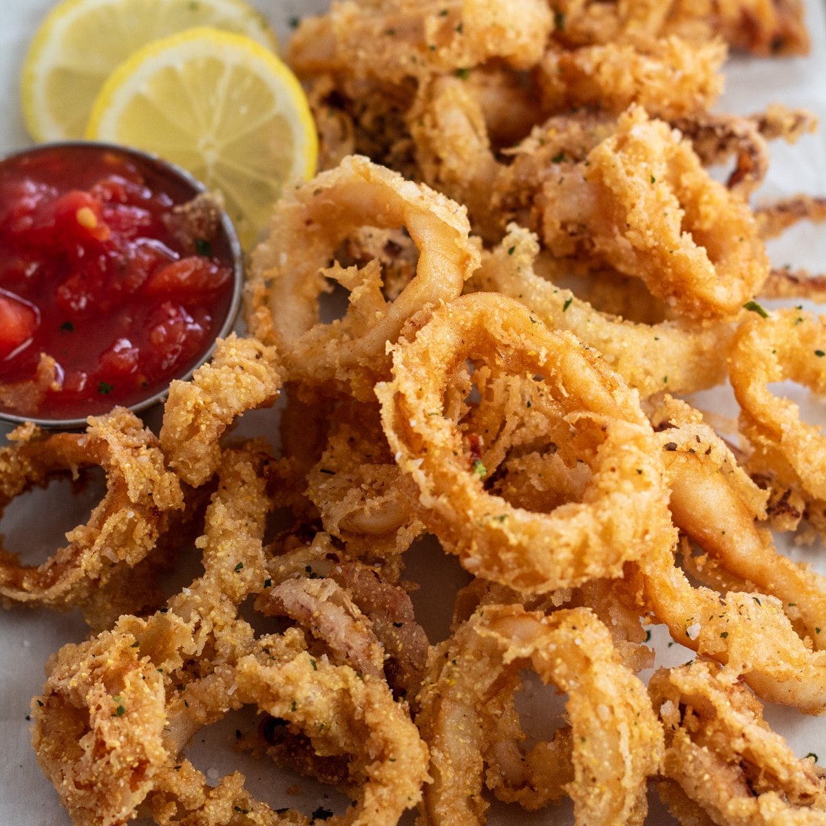 Overhead close-up op gefrituurde calamares geserveerd op blad pan.