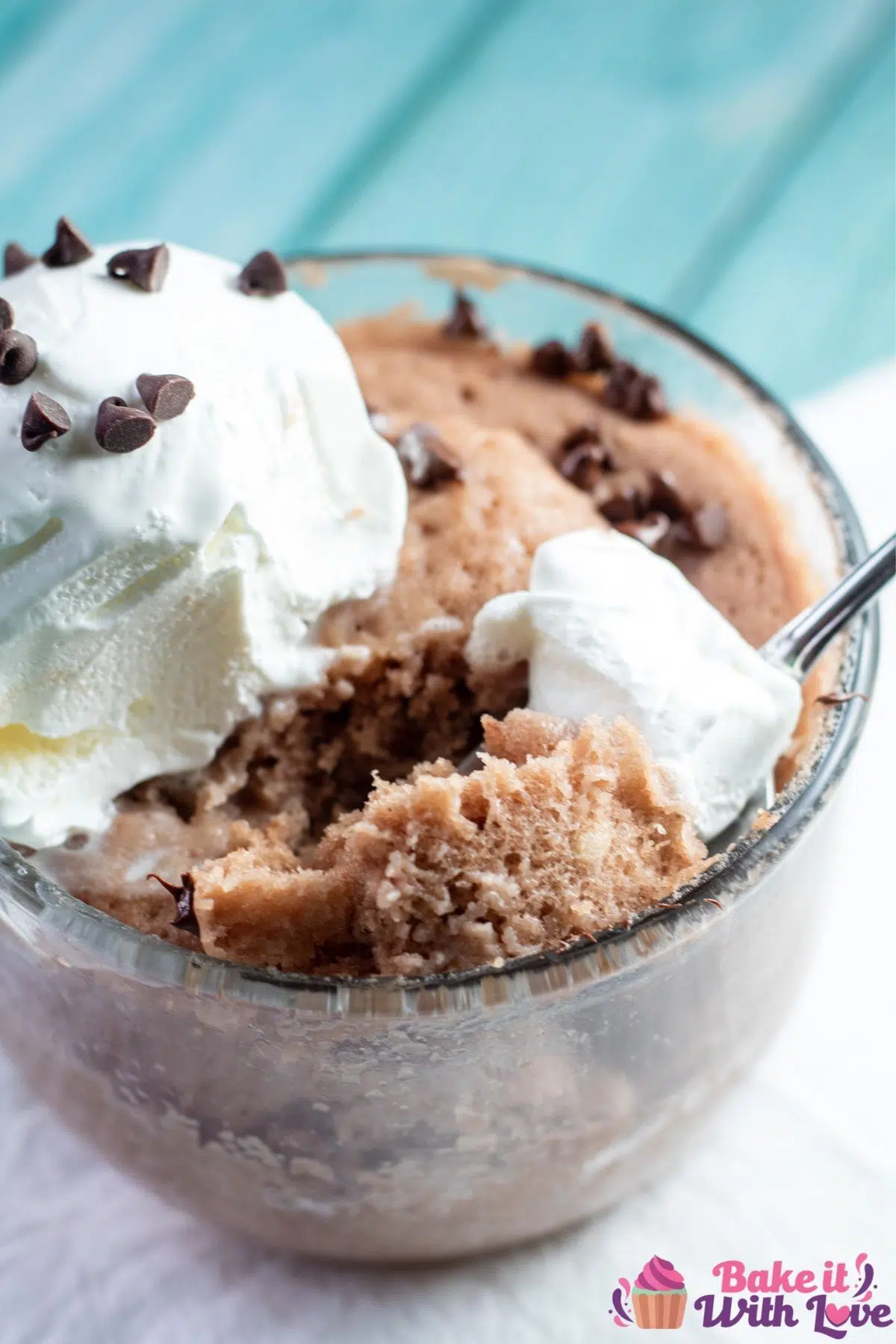 Chocolate protein powder mug cake with spoonful ready to enjoy.