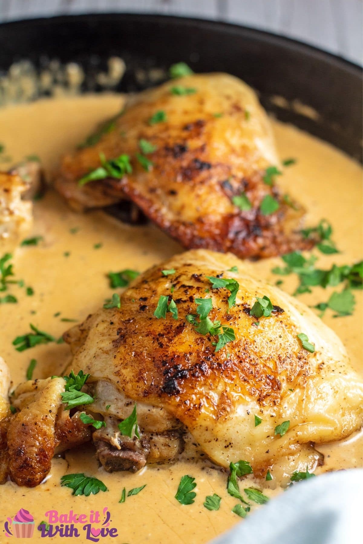 Tall image of cream cheese chicken in a cast iron pan.
