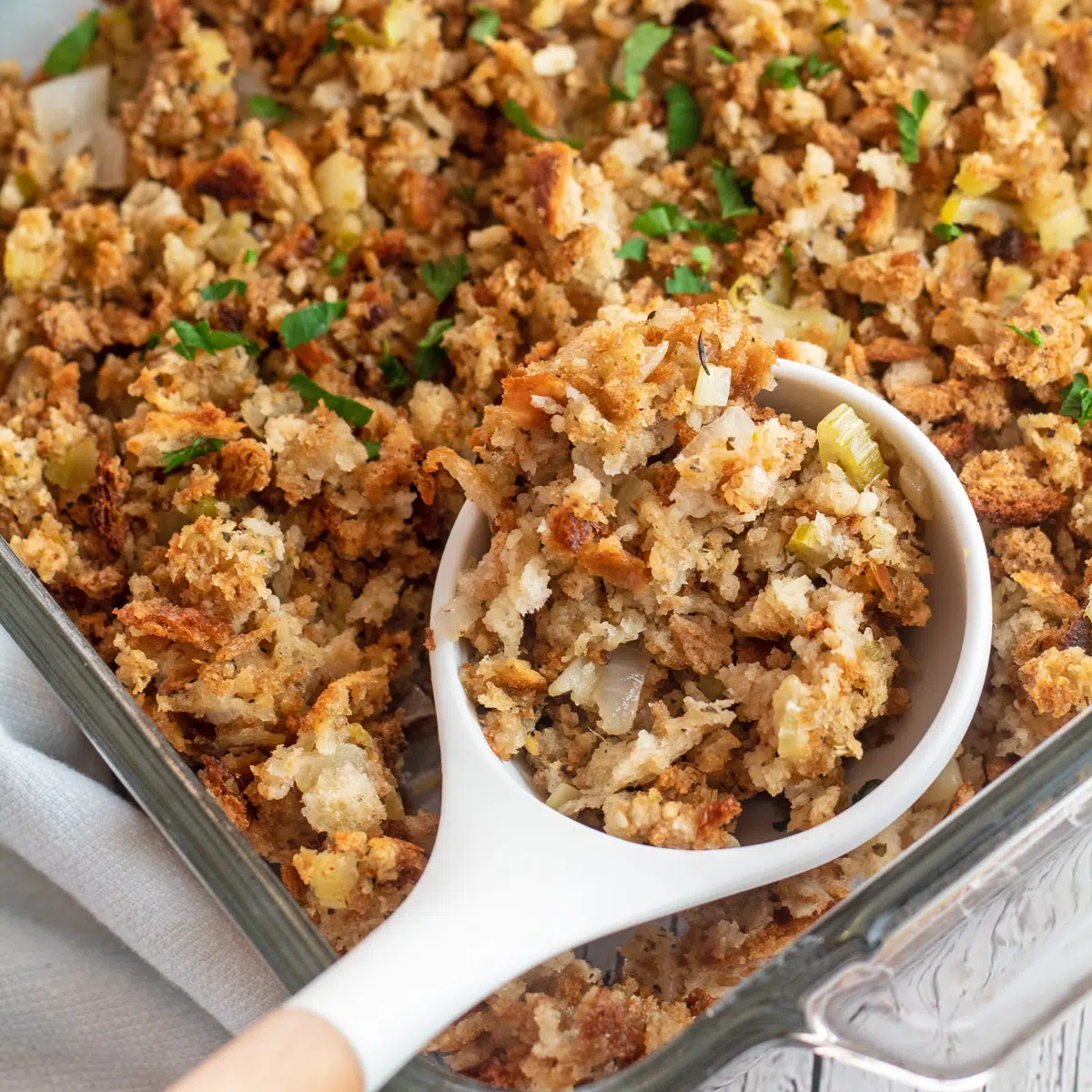 Easy stuffing with tasty herbs served in glass dish with serving spoon.