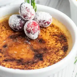 Closeup on a single serving of the toasted eggnog creme brulee in white ramekin.