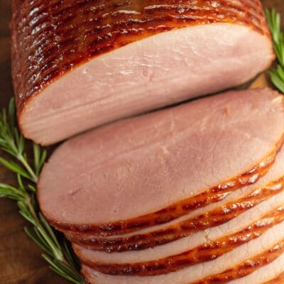 Sliced ham on a wooden cutting board.