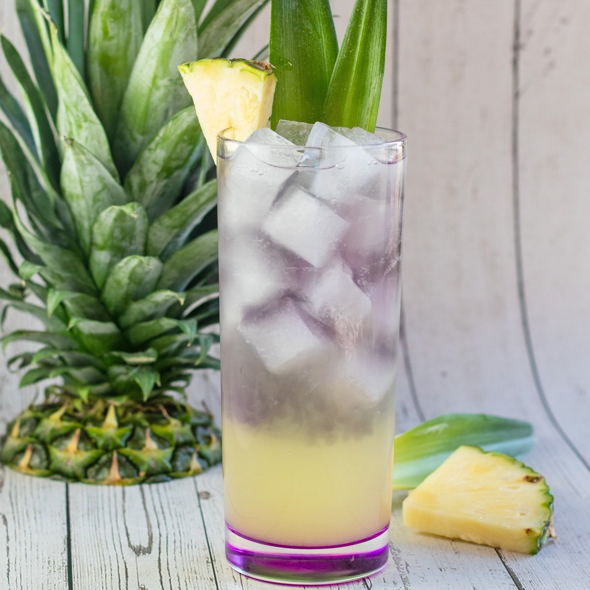 Royal hawaiiansk cocktail garneret med ananas og blade.