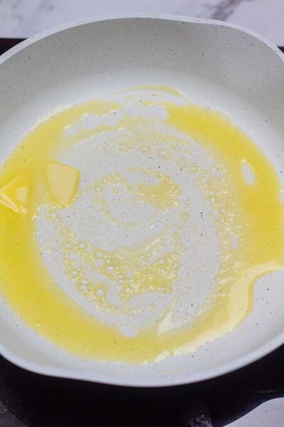 Process photo showing butter melted in frying pan.