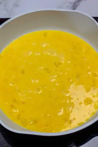 Process photo egg mixture in pan.
