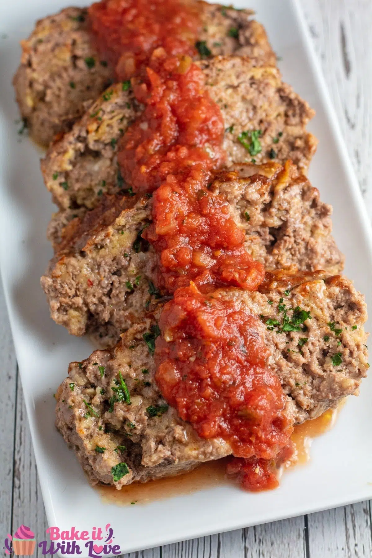 Tall image of taco mealoaf sliced with salsa over the top.