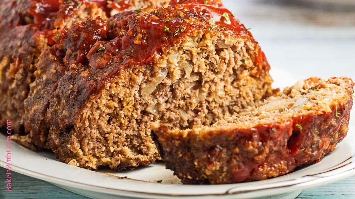 Wide image of the sliced meatloaf with oatmeal on white platter.