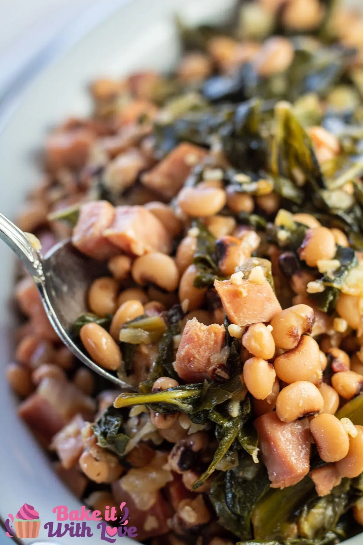 Tall image of the southern black eyed peas and collard greens being dished up.