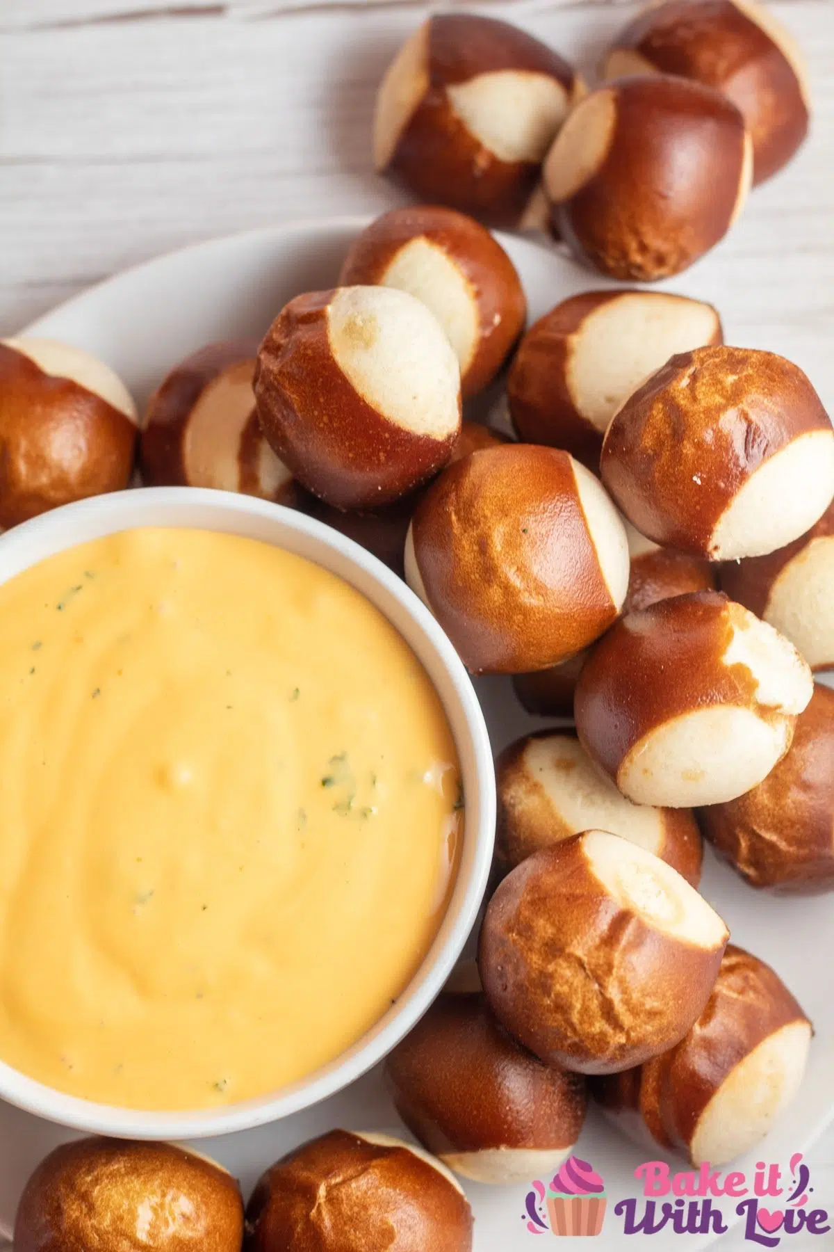 Tall image of cheese dip in a white bowl with pretzels around bowl.