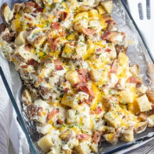 Square image of cheesy bacon ranch potatoes in a 9x13 dish..
